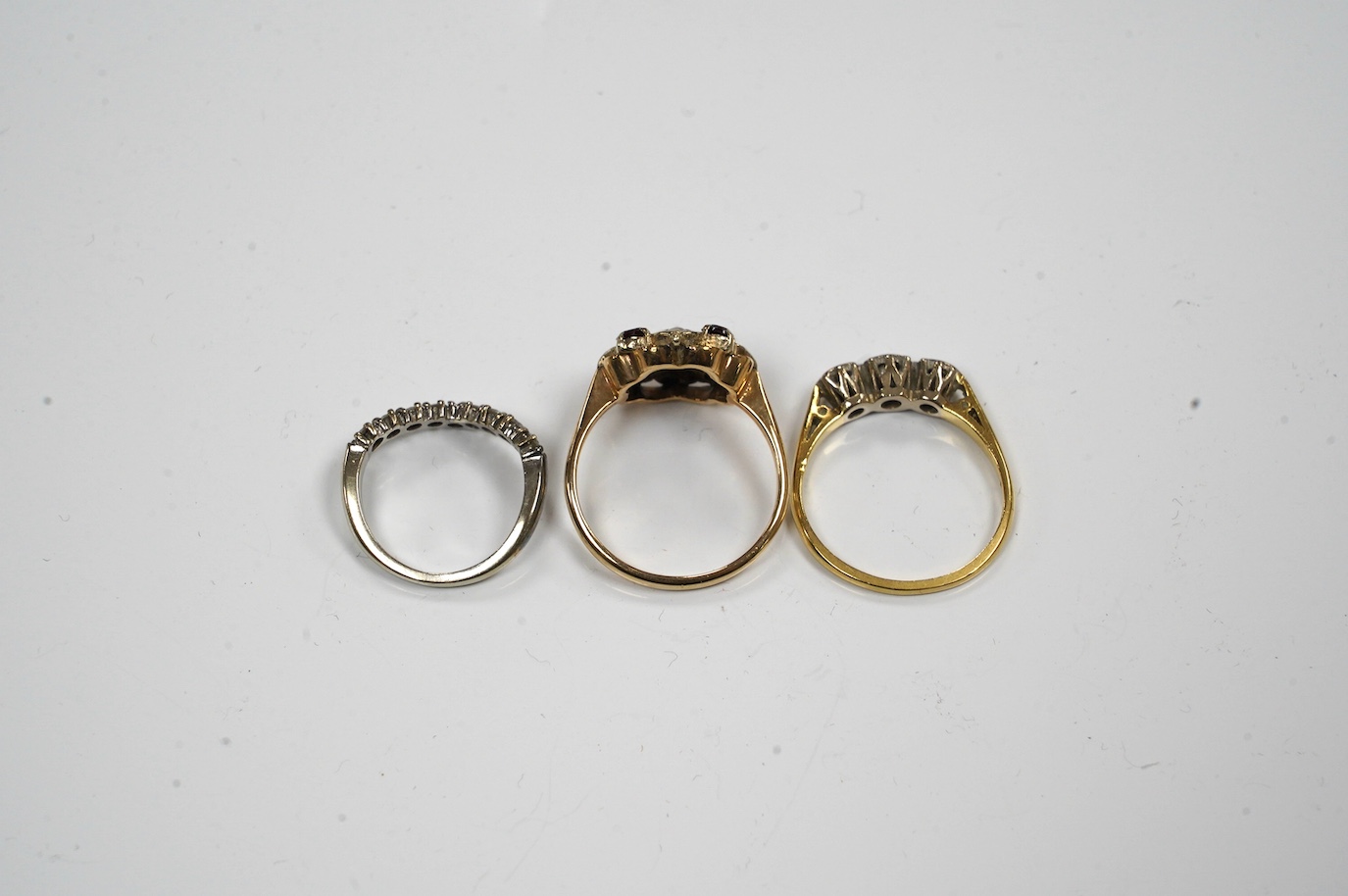 Two 18ct gold and diamond set rings including chevron shape and a 9ct gold, garnet and seed pearl set ring. Condition - fair